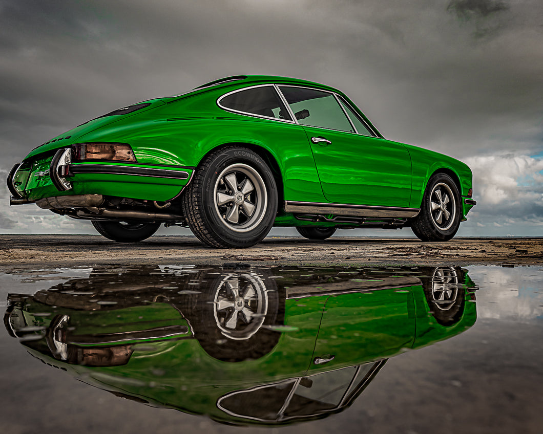 Photographie d'une voiture Porsche 911 verte avec son reflet, prise de côté