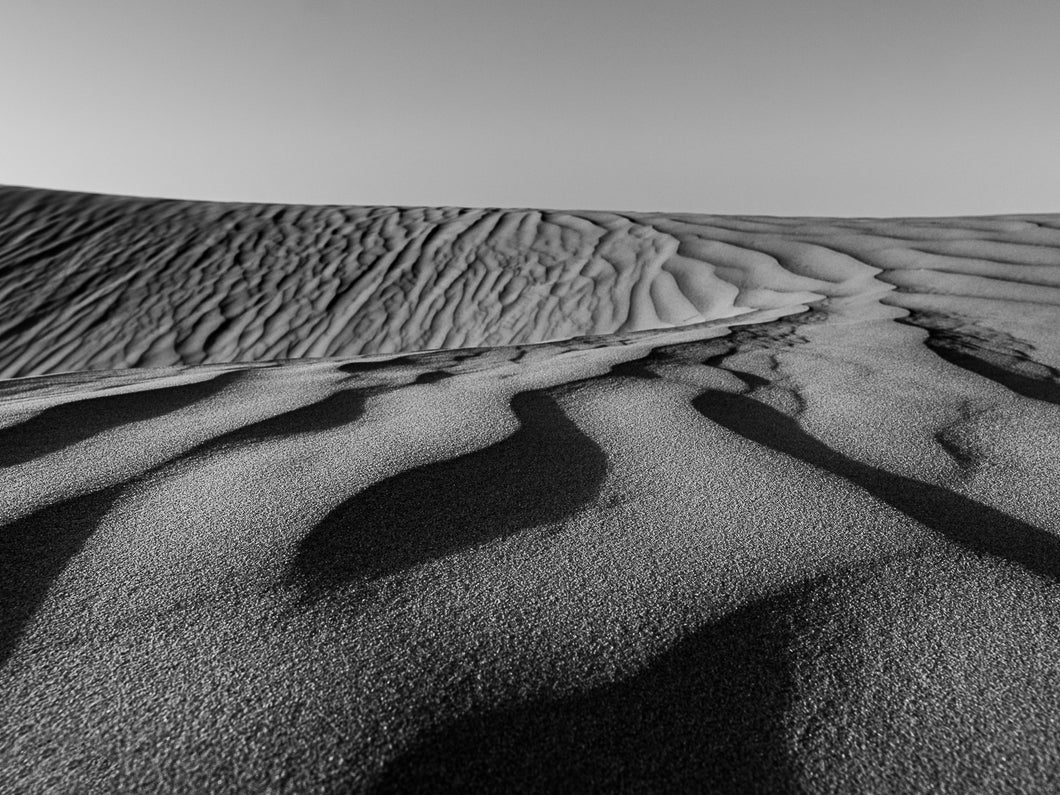 Sur la côte atlantique, les plages sont bordées par des dunes.Celle ci était vierge de traces humaines et de végétaux. Le vent avait dessiné ces multiples vaguelettes. La texture du sable est visible sur cette photographie de paysage minimaliste.  